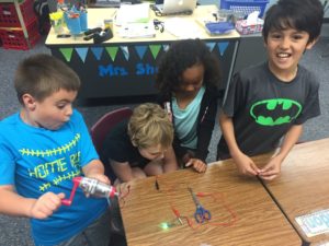 Third graders use a simple circuit to test objects as conductors or insulators. Courtesy NPPD.