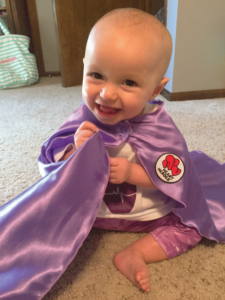 Evelyn Gregg smiles with her Heart Heroes purple cape. 