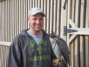 Chris Remmenga and his Northern Goshawk, Krieger. Remmenga uses a hood over the bird’s eyes to keep it calm when transporting to a hunting site. 