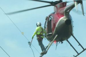 A helicopter is used to install bird flight diverters.