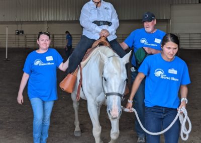 Volunteers assist Christine and therapy horse General at the horse show. 📸 Courtesy