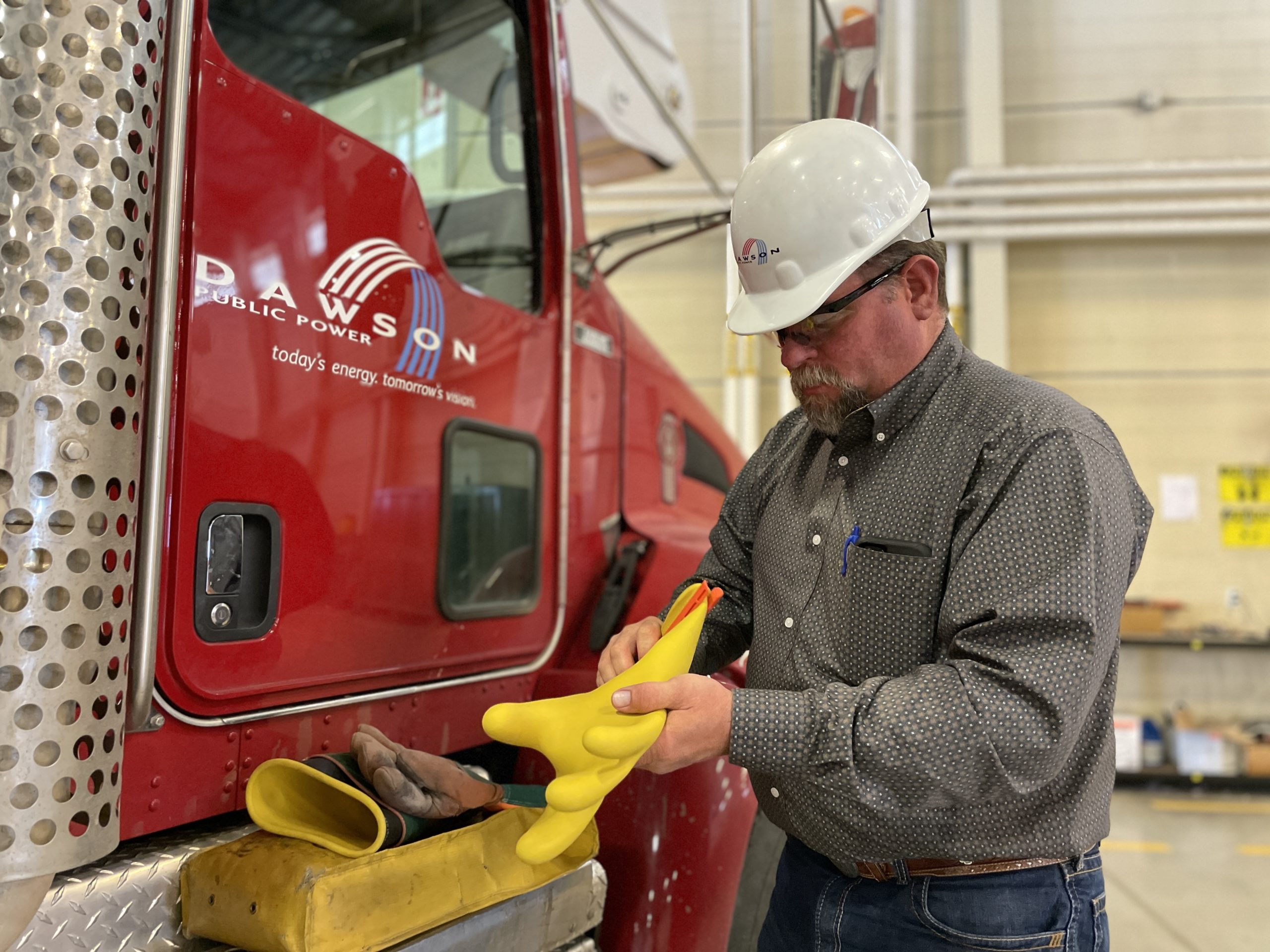 Safety Director Dean Kunkee inspects his rubber gloves for air leaks and other damage. 